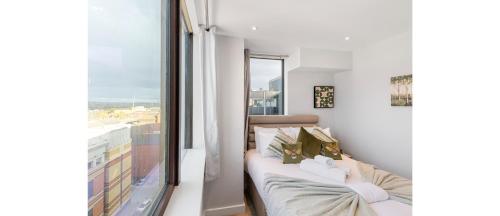 een woonkamer met een bank en een groot raam bij Harmonious Greens: Cozy 1-Bed Flat in Harrow in Harrow