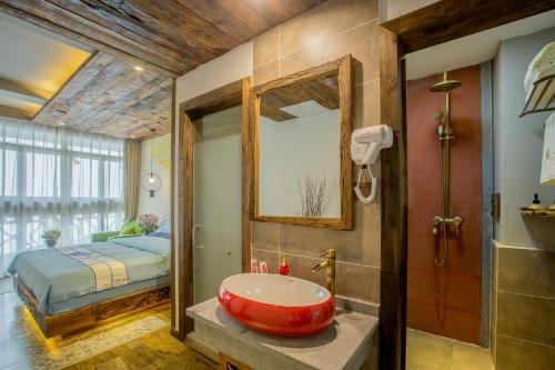 a bathroom with a red bath tub and a bed at Old Story Inn Lijiang Old Town in Lijiang