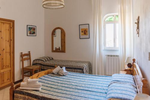 1 dormitorio con 2 camas y espejo en Portysud, en Lipari