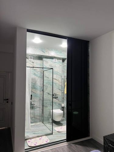a bathroom with a glass shower and a toilet at Hi-Tech Apartment in Tashkent