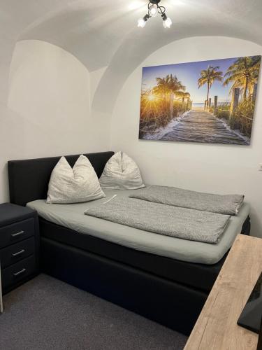 a bed in a room with a picture on the wall at Ferienwohnung Eden in Sachsenburg