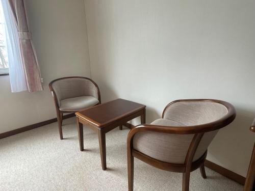 two chairs and a table in a room at マウンテンリゾート・マルガンタ Marganta in Madarao Kogen