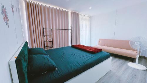 um pequeno quarto com uma cama e um sofá em Dong Thanh Ecolodge Homestay em Hoat