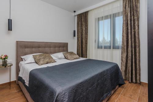 een slaapkamer met een groot bed en een raam bij Villa Anabel in Privlaka