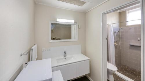 a white bathroom with a sink and a toilet at Coachman Hotel Motel in Parkes