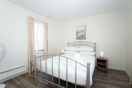 um quarto branco com uma cama e uma janela em Bright 3-Bed Waterfront by Beach & Creek em Seaford