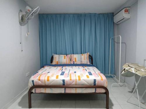 峇株巴辖Cempaka Homestay Batu Pahat 93的蓝色窗帘的房间的一张床位