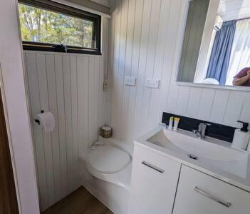 a white bathroom with a toilet and a sink at Tiny House 10 at Grampians Edge in Dadswells Bridge