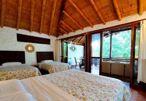 1 dormitorio con 2 camas en una habitación con ventanas en El Mirador de Punta Veleros en Los Órganos