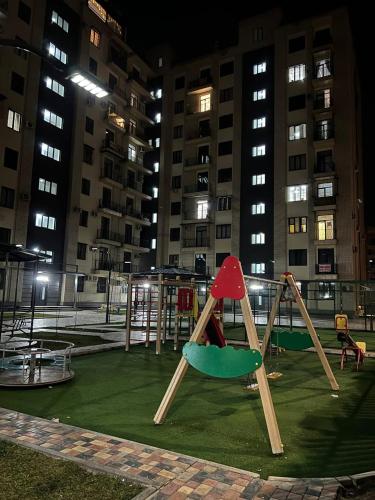a playground in a city at night with tall buildings at Hi-Tech Apartment in Tashkent