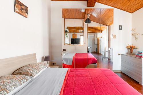 1 dormitorio con 2 camas con sábanas rojas y espejo en Social Costa-Holiday & Business Apartment en Bolonia