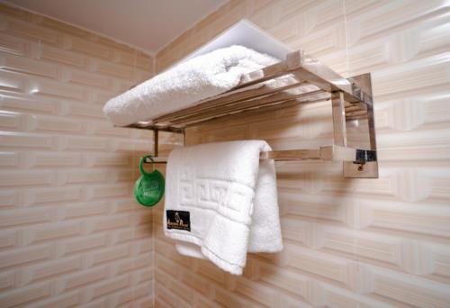 łazienka z białymi ręcznikami na wieszaku na ręczniki w obiekcie Adarsha Palace Hotel w mieście Chuknagar