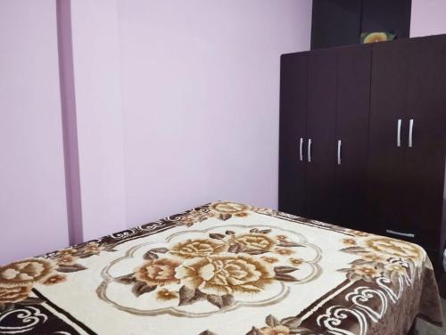 uma cama com um padrão floral ao lado de um armário em DEPARTAMENTO AMOBLADO em Cajamarca