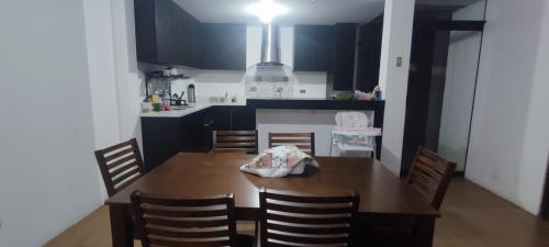 uma cozinha com uma mesa de madeira e uma sala de jantar em DEPARTAMENTO AMOBLADO em Cajamarca