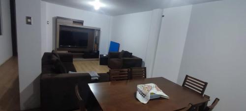uma sala de estar com uma mesa, um sofá e uma televisão em DEPARTAMENTO AMOBLADO em Cajamarca