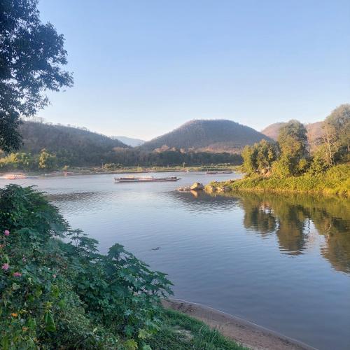 a river with a boat in the middle at Villa Chitchareune 2 in Luang Prabang
