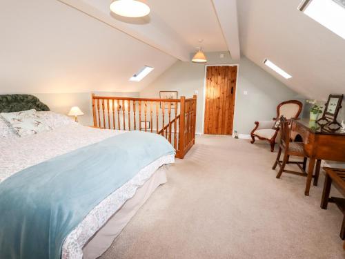a bedroom with a bed and a desk and a chair at The Laurels Barn in Oswestry