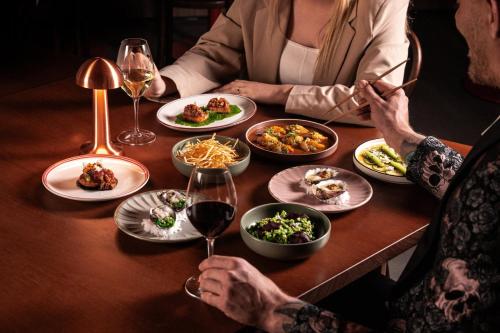 a group of people sitting at a table with plates of food at Hotel Indigo Sydney Potts Point by IHG in Sydney