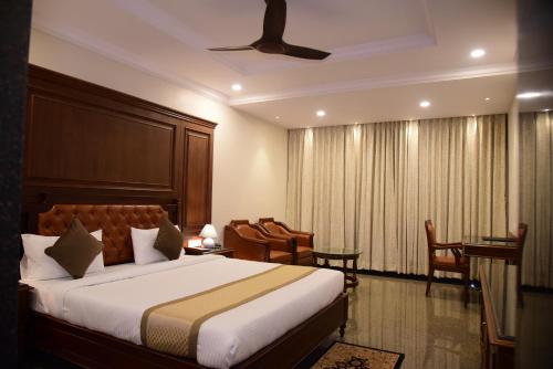 ein Hotelzimmer mit einem Bett und einem Stuhl in der Unterkunft Hotel Bishnu Palace in Jhārsuguda
