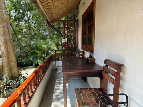 un tavolo in legno e una panca sul portico di una casa di Pagi Pagi villas ad Aonang Beach