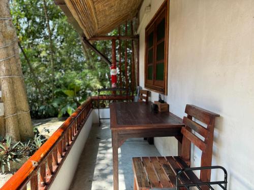 una mesa de madera y un banco en el porche de una casa en Pagi Pagi villas, en Ao Nang Beach