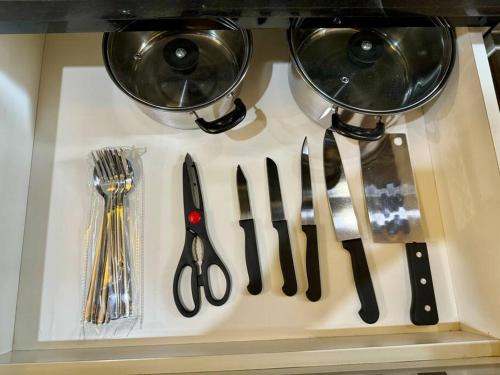 a bunch of kitchen utensils on a shelf at 2BR Luxury Cozy Homestay With Mall Access Greenbay Apartment Baywalk in Jakarta