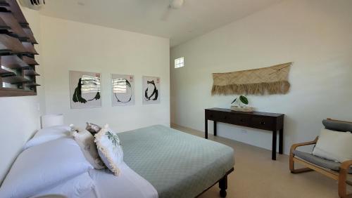 een slaapkamer met een bed, een tafel en een stoel bij Longview - stunning views, sleeps 7 in Port Vila