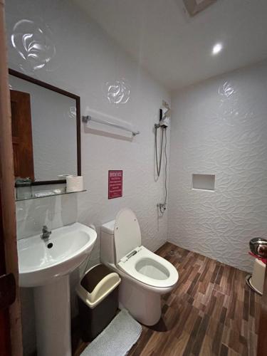 Łazienka z białą toaletą i umywalką w obiekcie Puyo Suites Homestay w mieście General Luna