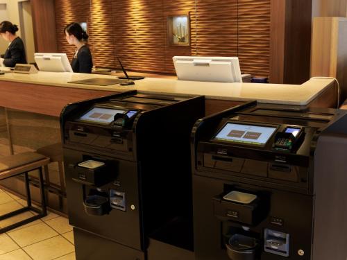 an office with two people at a counter with machines at JR Kyushu Hotel Nagasaki in Nagasaki
