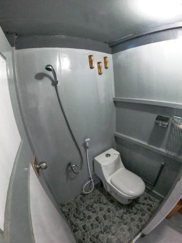 a small bathroom with a toilet and a shower at Trip komodo in Labuan Bajo