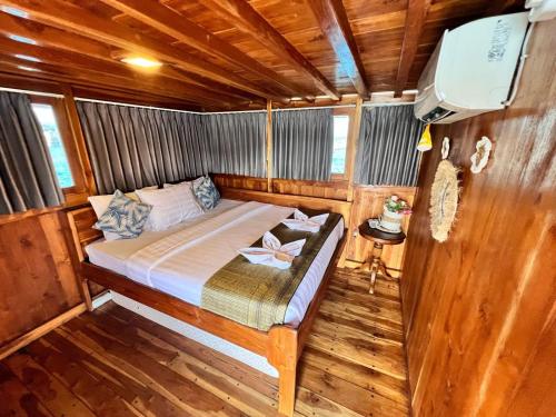 sypialnia z łóżkiem w drewnianej łodzi w obiekcie Trip komodo w Labuan Bajo