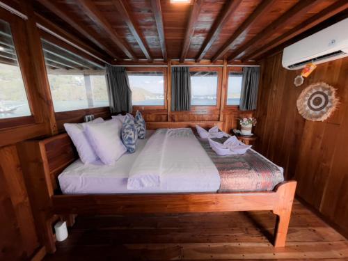 łóżko w środku pokoju na łodzi w obiekcie Trip komodo w Labuan Bajo