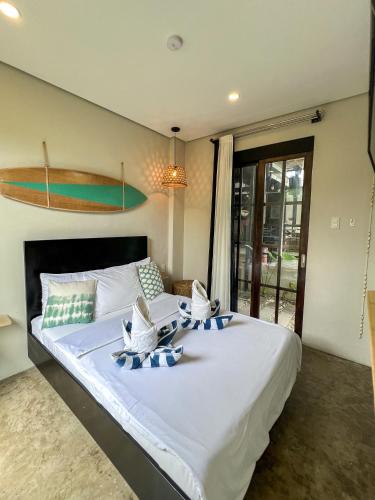 a large bed with blue and white pillows on it at Siargao Bed and Brewery in General Luna