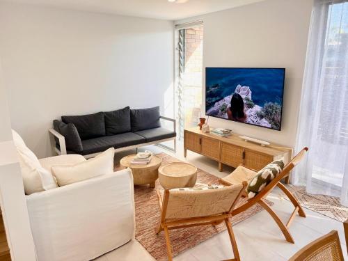 sala de estar con sofá y TV en Glen Eden Beach Resort en Peregian Beach