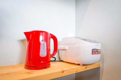 a red blender and a toaster sitting on a wooden shelf at サウナコテージ 清里高原から程近い八ヶ岳南山麓 富士山一望 露天風呂 in Hokuto