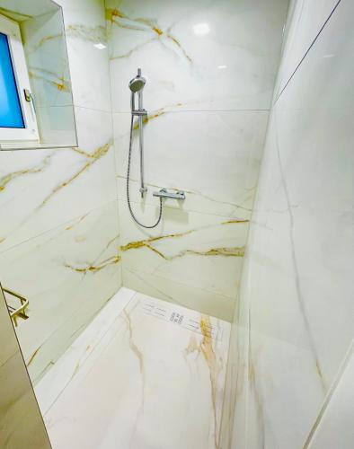 a bathroom with a shower with marble walls at YS Apartments in Marchtrenk