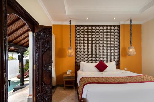 a bedroom with a bed and a large window at The Club Villas Seminyak in Seminyak