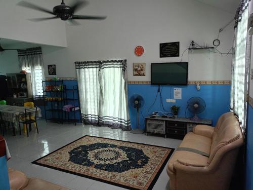 Il comprend un salon doté d'un canapé et d'une télévision à écran plat. dans l'établissement hayfa homestay private pool ipoh, à Ipoh