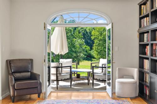 an open door to a patio with a table and chairs at 13-Acre Private Estate, Private Lake, Private Golf Range, Private Forest & Hiking Trails in Ross Corner