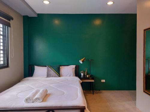 una camera da letto con un grande letto con una parete verde di Minimalist Vigan Condo Near Calle Crisologo a Vigan