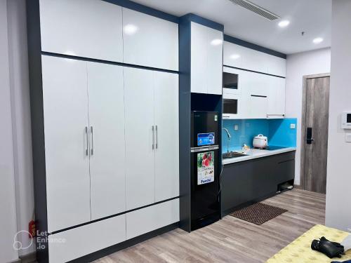 eine Küche mit weißen Schränken und einem Kühlschrank in der Unterkunft Anna House Homestay in Kim Quan