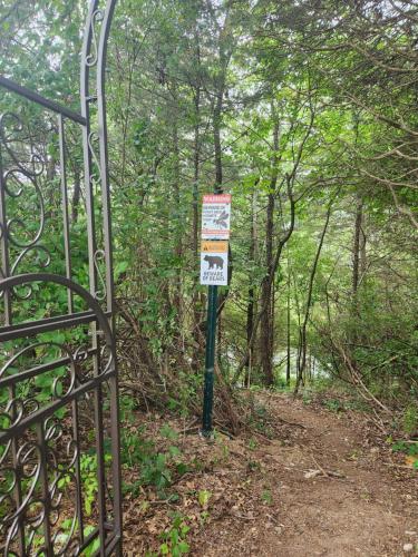 a gate with a sign on a trail in the woods at 13-Acre Private Estate, Private Lake, Private Golf Range, Private Forest & Hiking Trails in Ross Corner