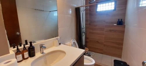 y baño con lavabo, ducha y aseo. en Minimalist Vigan Condo Near Calle Crisologo, en Vigan