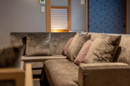 a couch with pillows on it in a living room at RESI STAY Fuyacho in Kyoto