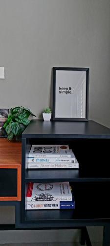 a black shelf with a stack of books on a desk at Minimalist Condo in Vigan Near Calle Crisologo in Vigan