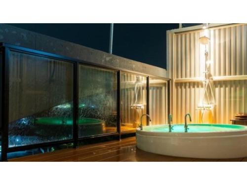 La salle de bains est pourvue d'une baignoire avec deux robinets. dans l'établissement Oita Onsen Business Resort Kyuan - Vacation STAY 50161v, à Ōita