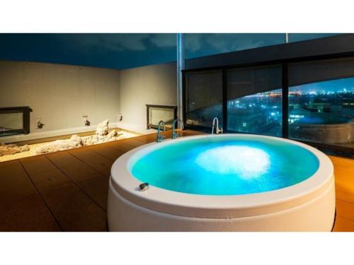 a bathroom with a bath tub with a large window at Oita Onsen Business Resort Kyuan - Vacation STAY 50166v in Oita