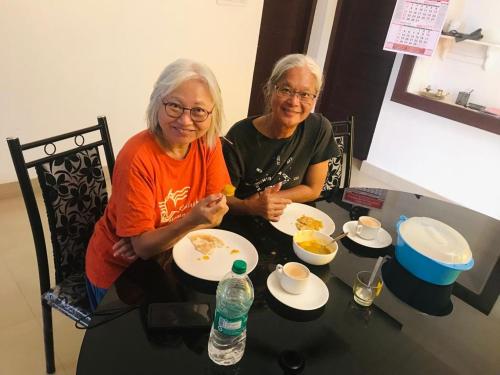 two older women sitting at a table eating food at Pupa Homestay &Surf school in Trivandrum
