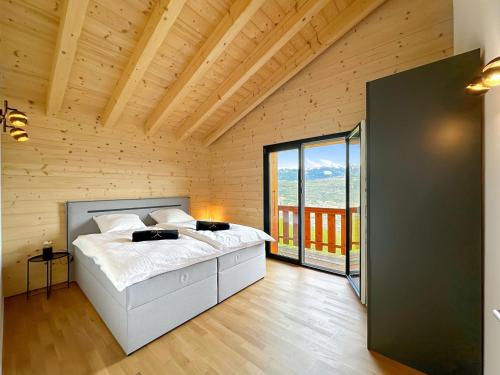 een slaapkamer met een groot bed in een houten kamer bij My Mountain Paradise - Swiss Alps in Rechy