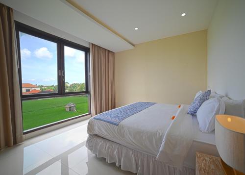 a bedroom with a bed and a large window at Villa Emilia Seminyak by Nagisa Bali in Kerobokan